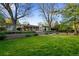 Expansive backyard featuring a lush lawn, a large patio, and mature trees that offer plenty of shade at 7900 Crest Dr, Lakewood, CO 80214