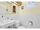 Well-lit powder room with subway tile, modern sink, and wood accents at 7900 Crest Dr, Lakewood, CO 80214
