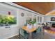Sunlit dining room with wood plank ceiling offers views of the beautifully landscaped backyard at 7900 Crest Dr, Lakewood, CO 80214
