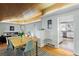 Open-concept dining room with wood floors seamlessly connects to the kitchen and living room at 7900 Crest Dr, Lakewood, CO 80214