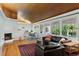 Cozy living room with wood floors, a fireplace, and large windows overlooking the backyard at 7900 Crest Dr, Lakewood, CO 80214