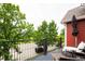 Cozy balcony with outdoor seating offering a relaxing view of lush trees and neighborhood streets at 7777 E 23Rd Ave # 1202, Denver, CO 80238
