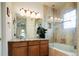 Bathroom featuring double sinks, vanity, and tiled shower with glass enclosure at 7777 E 23Rd Ave # 1202, Denver, CO 80238