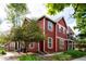 Exterior view of the attractive townhome with vibrant red siding, white trim, and well-maintained landscaping at 7777 E 23Rd Ave # 1202, Denver, CO 80238