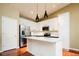 Modern kitchen features white cabinets, stainless steel appliances, and a center island at 7777 E 23Rd Ave # 1202, Denver, CO 80238