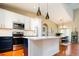 Well-appointed kitchen with modern appliances, white and blue cabinetry, and a seamless flow to the dining area at 7777 E 23Rd Ave # 1202, Denver, CO 80238
