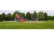 Outdoor playground with colorful slides and play structures nestled among mature trees in a park at 7777 E 23Rd Ave # 1202, Denver, CO 80238