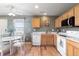 Cozy kitchen area with wooden cabinets, stainless steel microwave, and dining table with an adjacent large window at 7841 S Kalispell Cir, Englewood, CO 80112