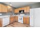 Functional kitchen featuring wood cabinets, a white refrigerator, and a dishwasher for convenience at 7841 S Kalispell Cir, Englewood, CO 80112