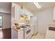 Cozy kitchen featuring white cabinets, gas range and tile flooring at 10762 E Exposition Ave # 336, Aurora, CO 80012