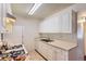 Compact kitchen features white cabinetry, gas range, tile floors, and modern appliances at 10762 E Exposition Ave # 336, Aurora, CO 80012