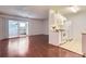 Bright living room featuring hardwood floors, a balcony and open access to a kitchen with white cabinetry at 10762 E Exposition Ave # 336, Aurora, CO 80012