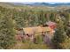 Scenic aerial view of a home nestled in the forest, surrounded by lush trees and mountain views at 7754 Swaps Trl, Evergreen, CO 80439