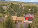 Aerial view of property showcasing the home, garage, driveway, and surrounding natural landscape at 7754 Swaps Trl, Evergreen, CO 80439