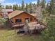 Aerial view of home with a wooden deck and hot tub, surrounded by lush greenery at 7754 Swaps Trl, Evergreen, CO 80439