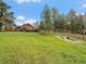 Private backyard oasis with lush lawn, home, and fire pit is ideal for relaxation and outdoor gatherings at 7754 Swaps Trl, Evergreen, CO 80439