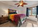 Cozy bedroom featuring carpet floors, unique ceiling fan, side table, and large window with outdoor views at 7754 Swaps Trl, Evergreen, CO 80439