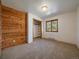Bright bedroom with a wood accent wall, carpet flooring, and a closet with built-in shelving at 7754 Swaps Trl, Evergreen, CO 80439