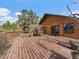 Spacious wood deck featuring a wooden railing overlooking a treed backyard at 7754 Swaps Trl, Evergreen, CO 80439