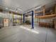 Expansive garage featuring a car lift, high ceilings and a well-lit workspace at 7754 Swaps Trl, Evergreen, CO 80439