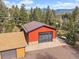 Aerial view of a detached garage nestled among trees, with mountain views in the background at 7754 Swaps Trl, Evergreen, CO 80439