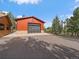 Spacious garage with an automatic door, adjacent to a charming home amidst lush trees at 7754 Swaps Trl, Evergreen, CO 80439