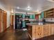 Open kitchen with unique blue cabinets, modern appliances, slate floors, and a peninsula with a stone countertop at 7754 Swaps Trl, Evergreen, CO 80439
