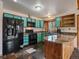 Well-lit kitchen with unique blue cabinets, slate floors, and a peninsula with a stone countertop at 7754 Swaps Trl, Evergreen, CO 80439