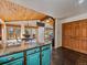 A modern kitchen with stone countertops, a wood ceiling, and an adjacent dining area with large windows at 7754 Swaps Trl, Evergreen, CO 80439