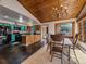 Open kitchen featuring blue cabinets, granite counters, tiled floor, dining area, wood ceiling, and natural light at 7754 Swaps Trl, Evergreen, CO 80439