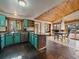 Open kitchen features blue cabinets, granite counters, tiled floor, dining nook, wood ceiling, and natural light at 7754 Swaps Trl, Evergreen, CO 80439