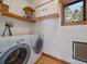 Functional laundry room with washer, dryer, and convenient storage shelves at 7754 Swaps Trl, Evergreen, CO 80439