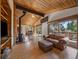 Open-concept living space featuring a wood-burning stove, hardwood floors, and large windows with views to the outdoors at 7754 Swaps Trl, Evergreen, CO 80439