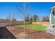 Private backyard with mulch beds, trees and lush grass, surrounded by a wooden fence at 4871 S Dunkirk Way, Centennial, CO 80015