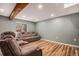 Finished basement boasts wood-look floors, recessed lighting, and two reclining couches at 4871 S Dunkirk Way, Centennial, CO 80015