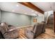 Finished basement with wood-look floors, exposed beam, and two reclining couches at 4871 S Dunkirk Way, Centennial, CO 80015