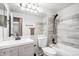 Modern bathroom with horizontally tiled shower, floating vanity, and dark fixtures at 4871 S Dunkirk Way, Centennial, CO 80015