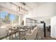 Bright dining room featuring large window, modern lighting, table setting, and open access to other living spaces at 4871 S Dunkirk Way, Centennial, CO 80015