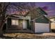 Charming green two-story home featuring brick accents, attached garage, and manicured lawn at 4871 S Dunkirk Way, Centennial, CO 80015