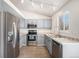 Kitchen featuring stainless appliances, gray cabinets, granite countertops, and wood look floors at 4871 S Dunkirk Way, Centennial, CO 80015