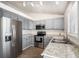Kitchen with stainless appliances, gray cabinets, granite countertops, and wood look floors at 4871 S Dunkirk Way, Centennial, CO 80015
