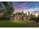 Spacious backyard with a deck, sunroom, mature trees, and a well-maintained lawn at 10450 Iris Way, Broomfield, CO 80021