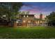 The exterior of the home boasts a sunroom, wood deck, and mature trees and a spacious lawn at 10450 Iris Way, Broomfield, CO 80021