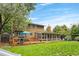 Spacious backyard featuring a sunroom, deck, and a well-maintained lawn, perfect for outdoor activities at 10450 Iris Way, Broomfield, CO 80021