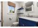 Stylish bathroom featuring a navy vanity with marble countertop and bright window at 10450 Iris Way, Broomfield, CO 80021