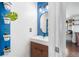 Modern bathroom featuring floating vanity, stylish lighting, blue accent wall and greenery at 10450 Iris Way, Broomfield, CO 80021