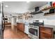 Updated kitchen with stainless steel appliances, granite counters, open shelving and view to living room at 10450 Iris Way, Broomfield, CO 80021