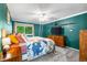 Well-lit bedroom with large window, teal walls, and ceiling fan at 10450 Iris Way, Broomfield, CO 80021