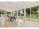 Bright sunroom with large windows offering backyard views, with a dining table and swing chair at 10450 Iris Way, Broomfield, CO 80021