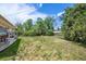An expansive backyard with a large grassy area, mature trees, and patio at 4855 E Atlantic Pl, Denver, CO 80222